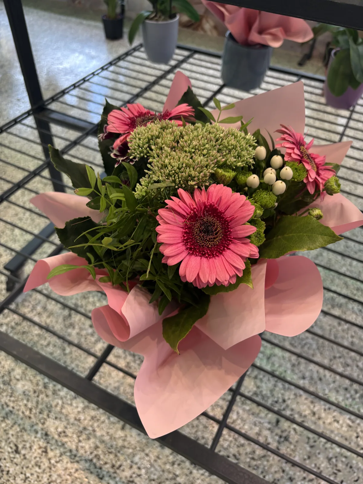 Rosa Gerbera-Strauß in zartrosa Papier